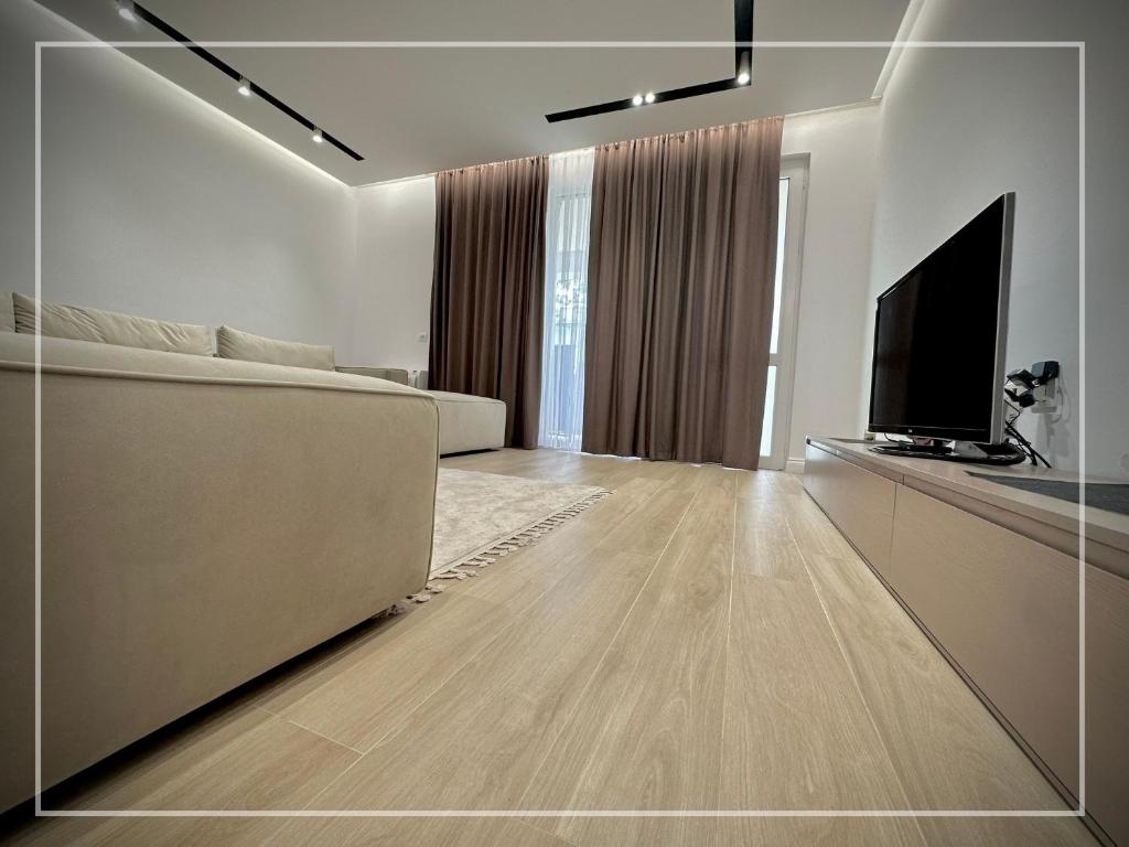 a living room with a couch and a flat screen tv at Luxury Apartment - San Pietro in Durrës
