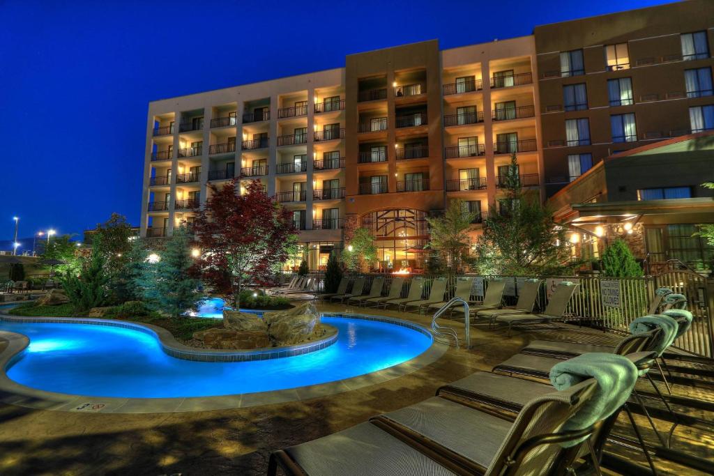a hotel with a swimming pool at night at Courtyard by Marriott Pigeon Forge in Pigeon Forge
