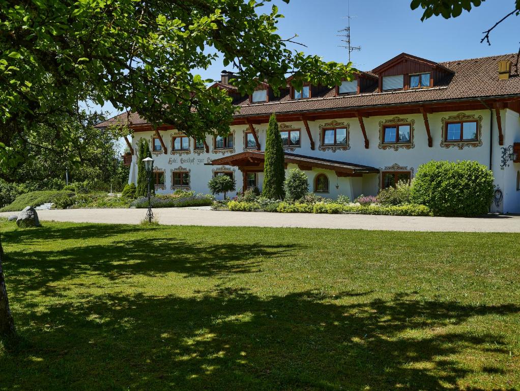 ein großes weißes Haus mit Rasen davor in der Unterkunft Landhotel zur Grenze in Isny im Allgäu