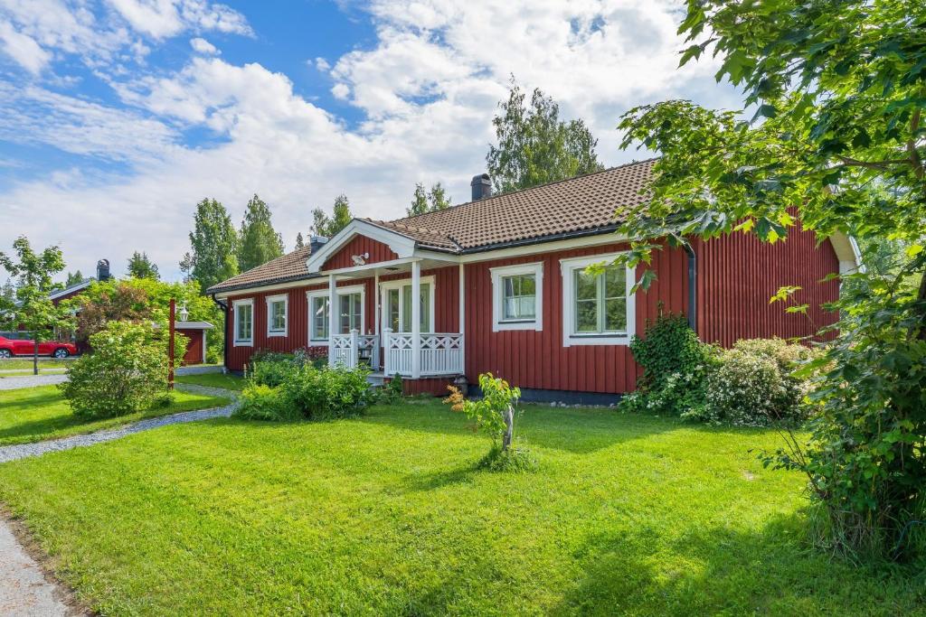 une maison rouge avec une cour verdoyante dans l'établissement Scenic Seaside Retreat near Northvolt Ett, à Skellefteå