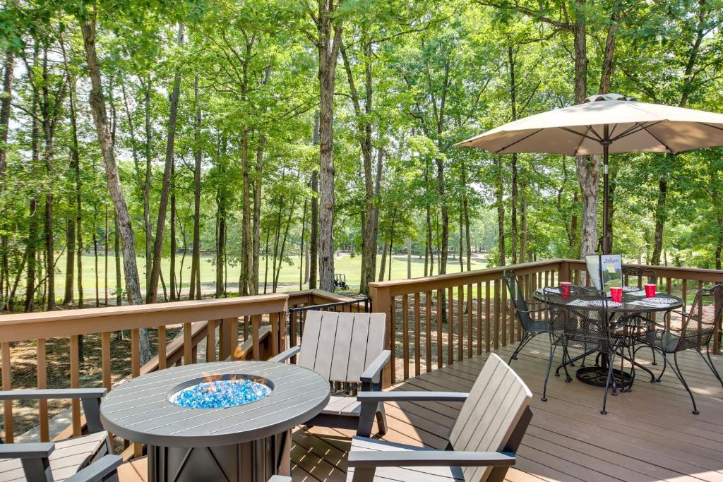 a deck with a table and chairs and an umbrella at Hot Springs Village Golf Getaway with Deck! in Hot Springs Village