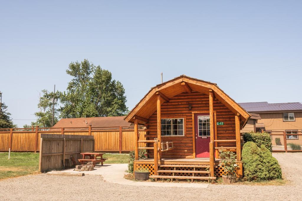 Cabaña de madera con porche y banco en Redwood Coast Cabins and RV Resort, en Eureka