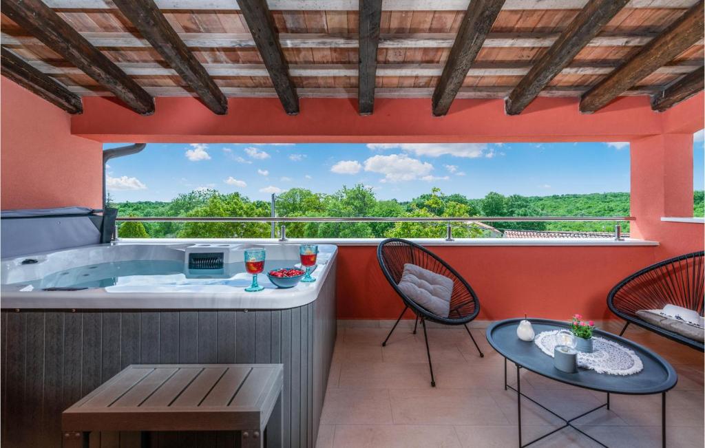 uma varanda com uma banheira, uma mesa e cadeiras em Amazing Home In Krnica With House A Panoramic View em Belavići