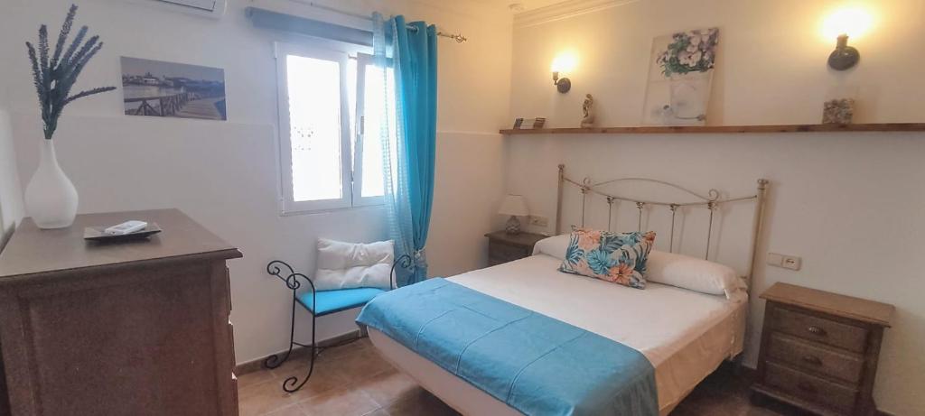 Un dormitorio con una cama y un escritorio y una ventana. en Estudio Patio San Paulino II, en Barbate