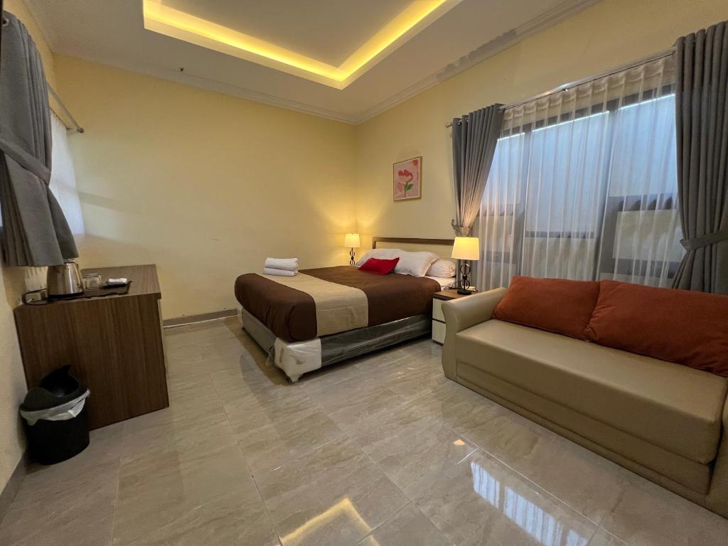 una camera d'albergo con letto e divano di Casa Familia Syariah a Sleman