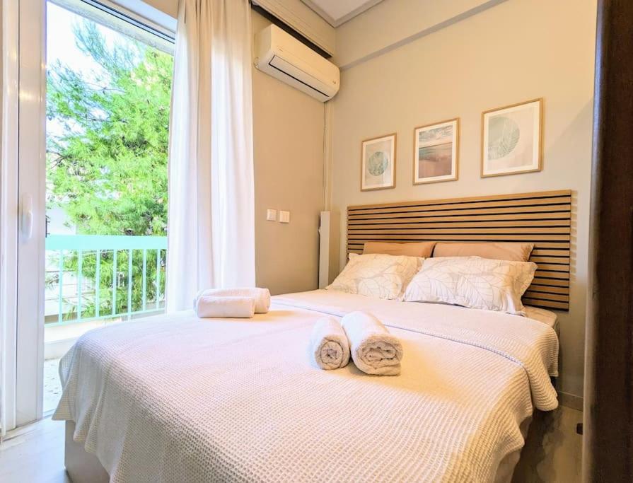 sypialnia z 2 ręcznikami na łóżku z oknem w obiekcie Beautiful 1 bedroom flat near Olympic Stadium w Atenach