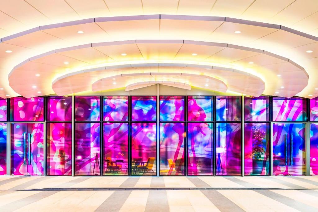 a rendering of the lobby of a building with colorful windows at Le Meridien Putrajaya in Putrajaya