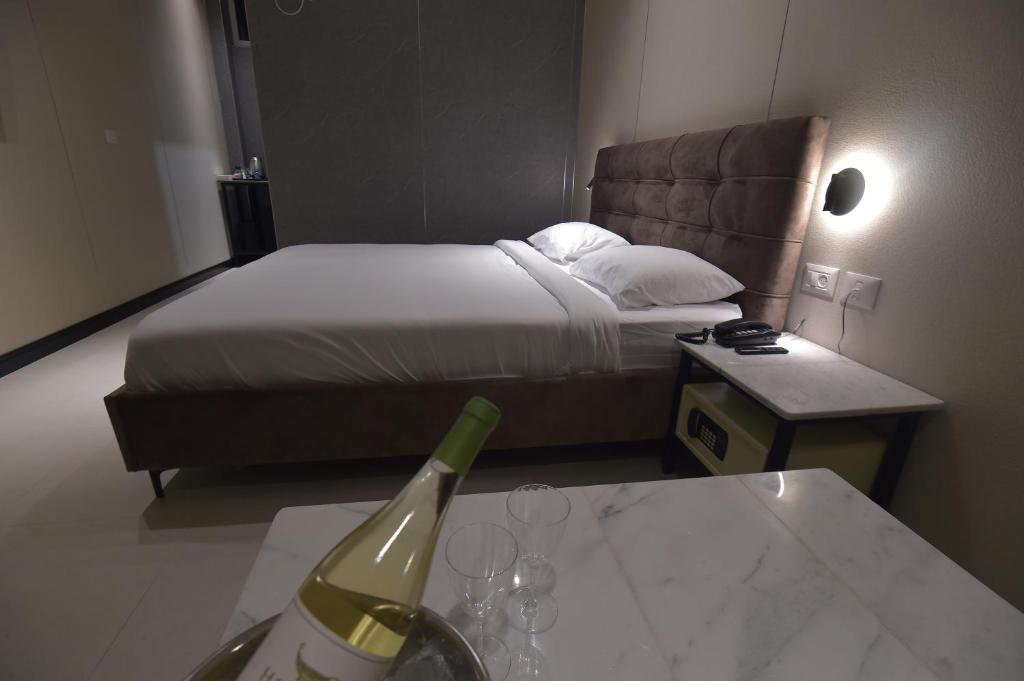 a hotel room with a bed and a table with wine glasses at מלון הברון in Ramat Eliyyahu