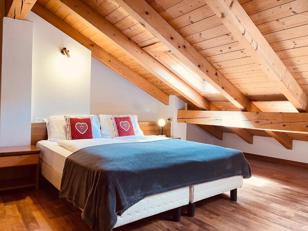 a bedroom with a large bed with wooden ceilings at Elga Residence - Relax in Alta Valtellina - Bormio in Valdisotto