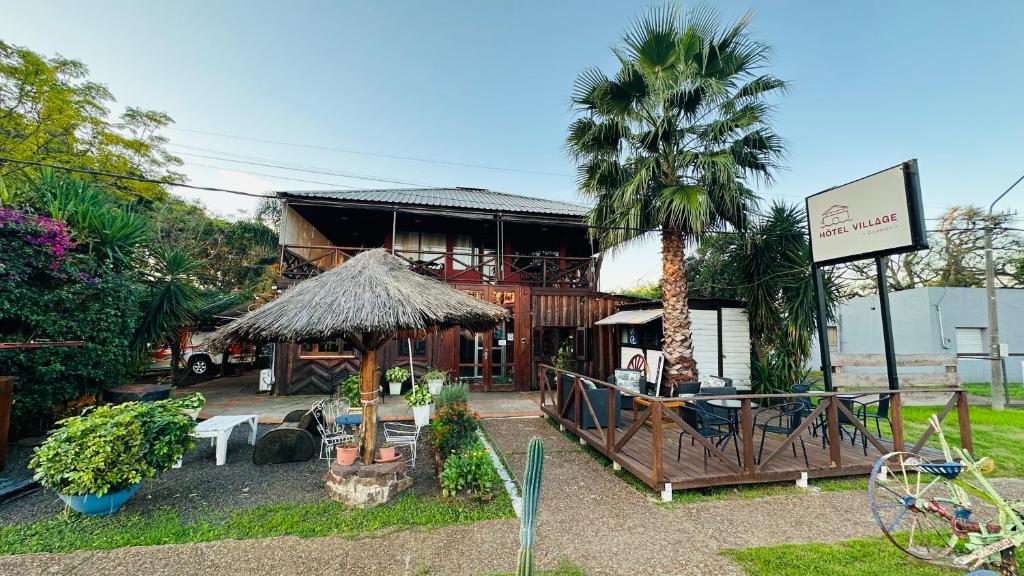 um edifício com uma palmeira em frente em Hotel Village Termas de Dayman em Termas del Daymán