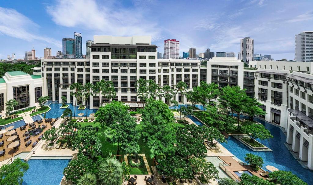 an aerial view of a building with trees and a city at Siam Kempinski Hotel Bangkok - SHA Extra Plus Certified in Bangkok
