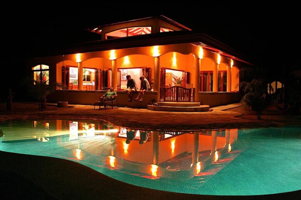 a house with a swimming pool at night at Villa Pavones in Pavones