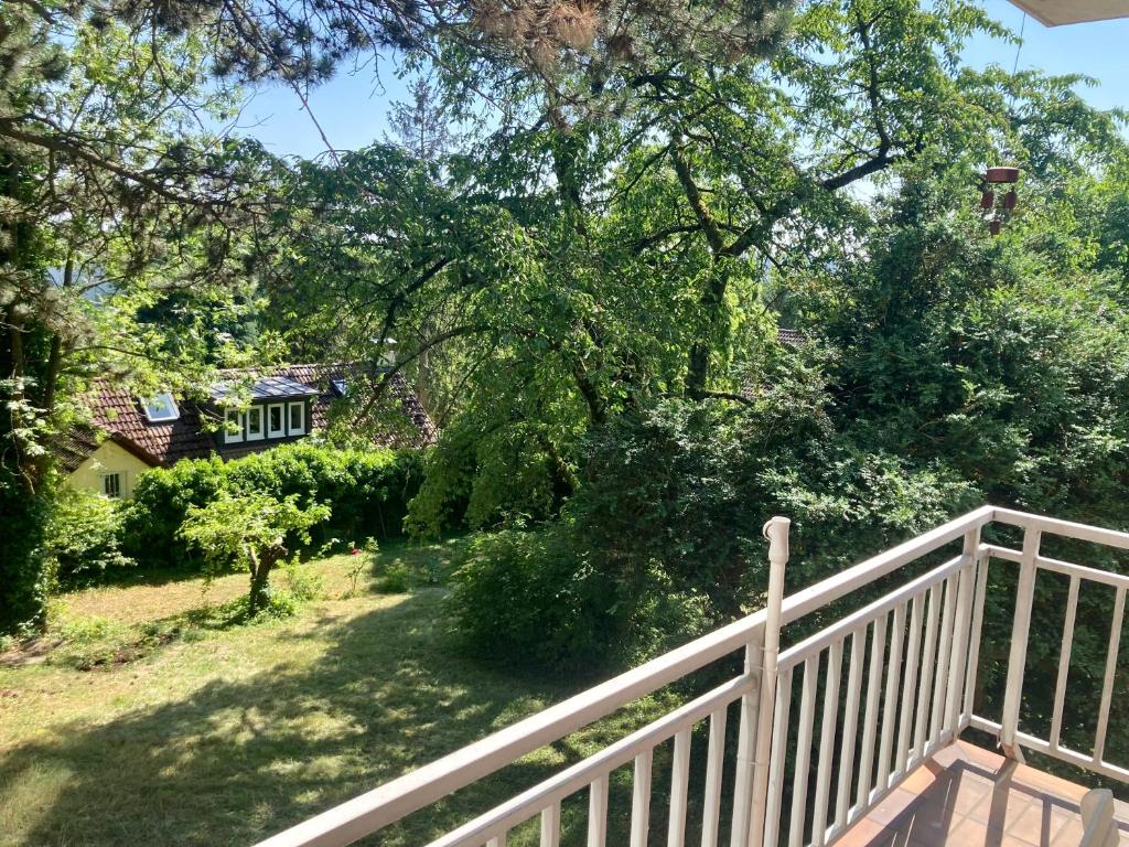 ein Haus mit einem weißen Zaun und Bäumen in der Unterkunft WORKATION Nature View mit Balkon, indoor Pool, Küche Tiefgarage auf Anfrage in Wiesbaden