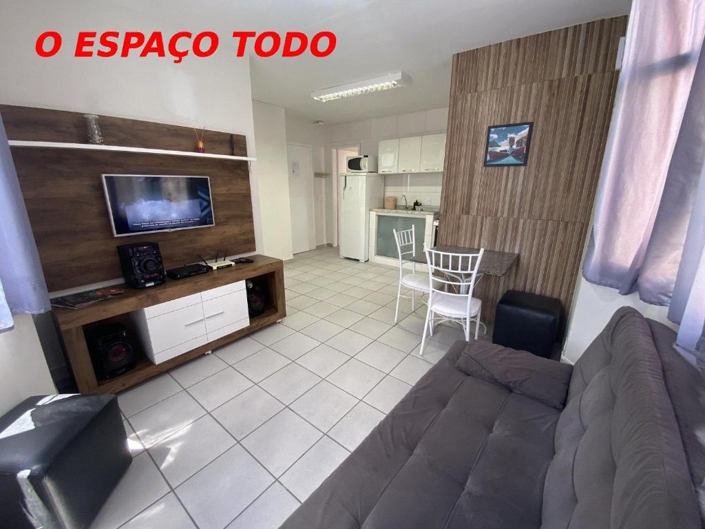 een woonkamer met een bank en een tv bij Apart 2 suítes Prox Cambuí Wi-Fi Gar Var Note Pet ap21 in Campinas