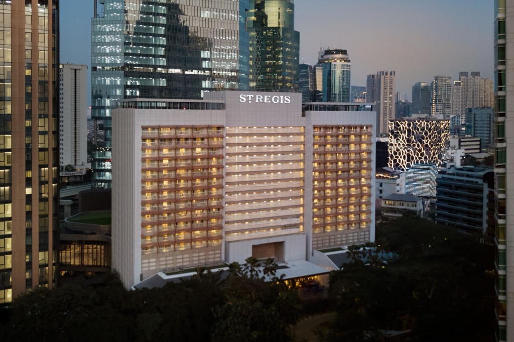 a building with a sign on it in a city at The St. Regis Jakarta in Jakarta