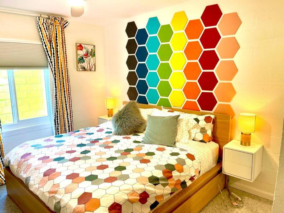 a bedroom with a bed with a colorful wall at The Flamingo Palms private 1bd 1ba Unit in Duplex in Palm Springs