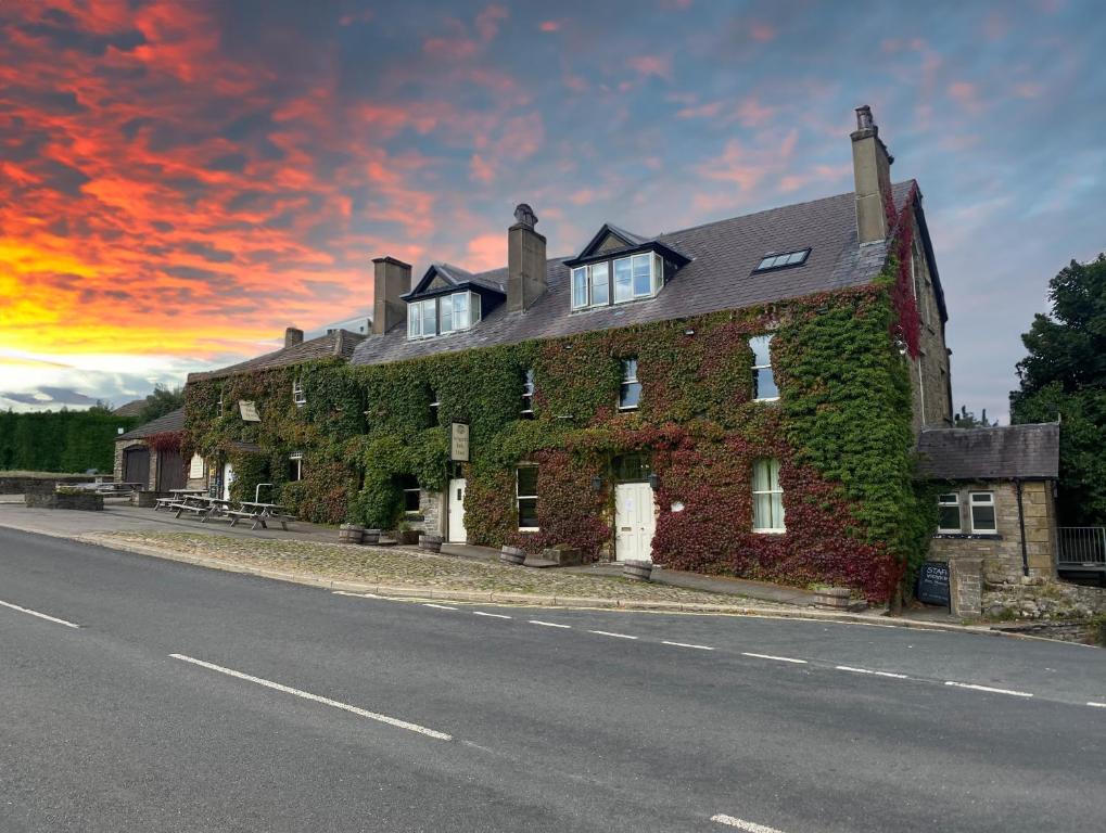 an ivy covered building on the side of a road at Aysgarth Falls Hotel & Restaurant in Aysgarth