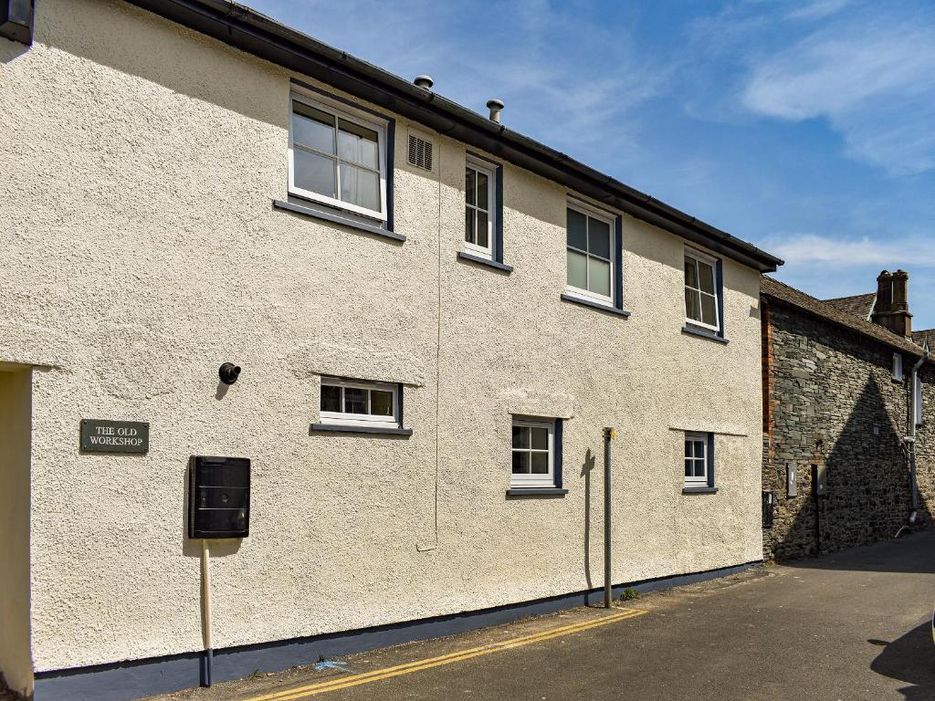 a large white brick building with windows on a street at The Old Workshop in Keswick