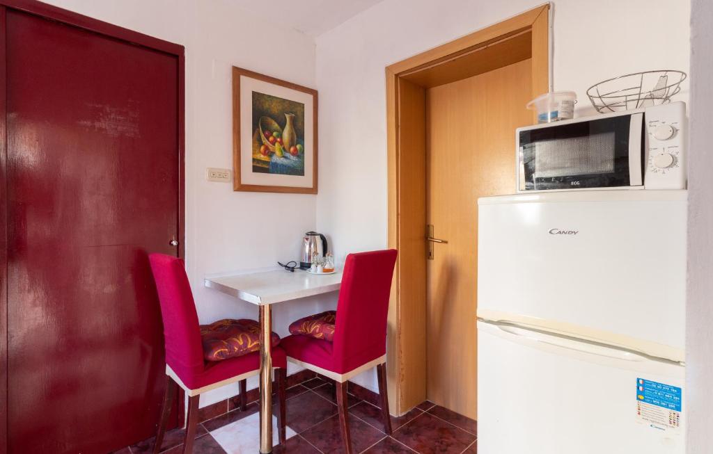 a kitchen with a table and two chairs and a refrigerator at Apartments Ruža Dragove Dugi otok in Dragove