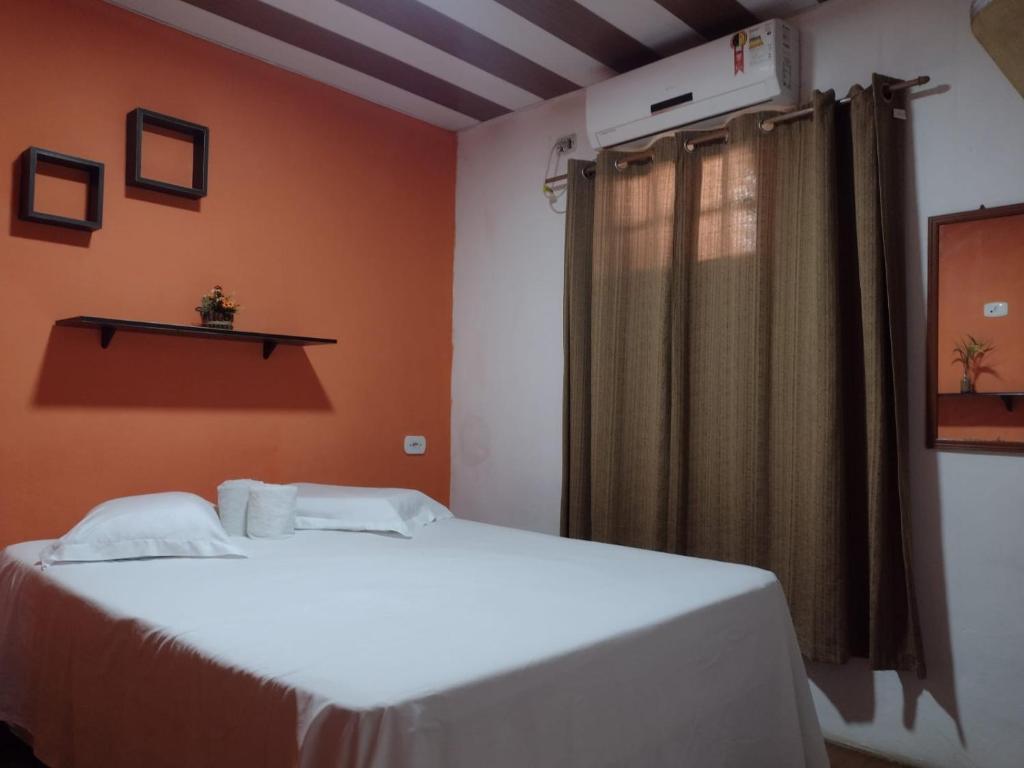 2 camas en una habitación con paredes de color naranja en Pousada Alto das Galés, en Maragogi