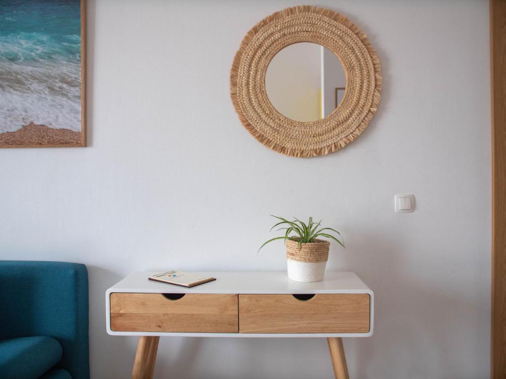 une table avec un miroir et une plante en pot dans l'établissement Sunny Apartments, à Stomorska