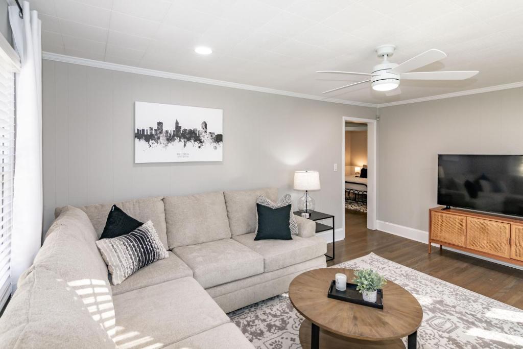 ローリーにあるStylish & Comfy 5 Location Private Backyard Updated Close to Downtown Walkableのソファと薄型テレビのあるリビングルーム