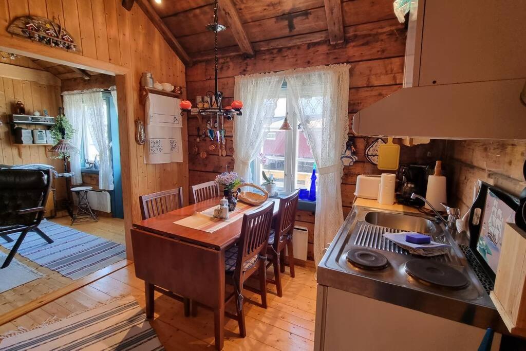 瑟弗根的住宿－Koselig rorbu på Tind，小屋内的厨房配有桌椅