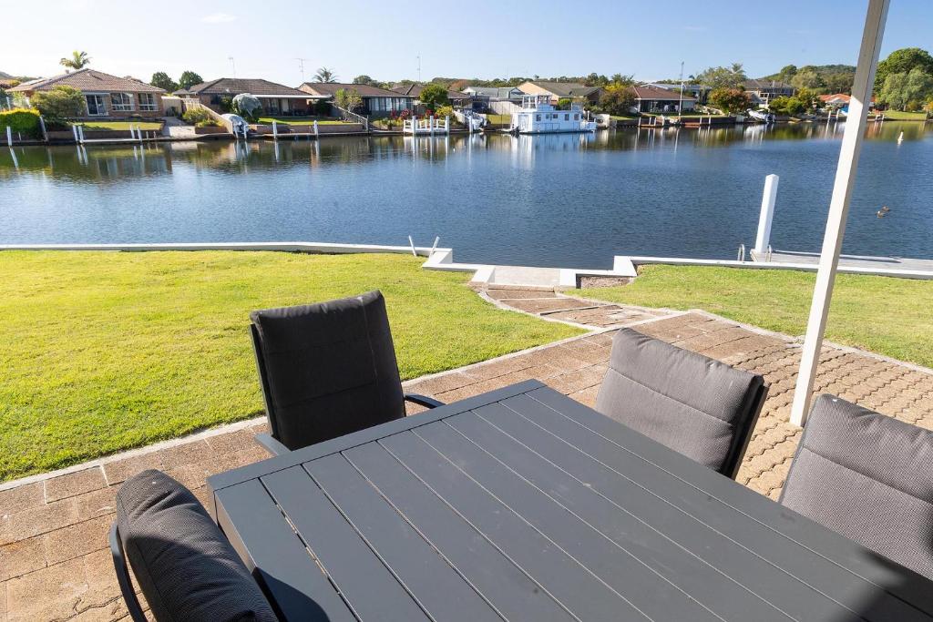 a table and chairs with a view of a river at 23 Elouera Crescent in Forster