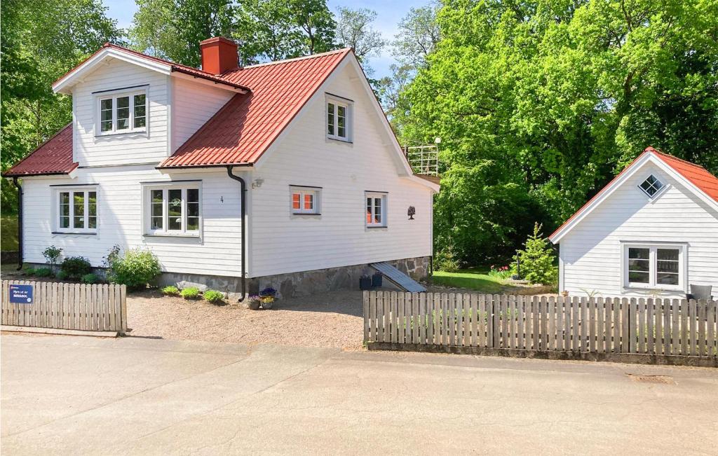 Casa blanca con techo rojo y valla en 2 Bedroom Amazing Home In rkelljunga, en Orkelljunga