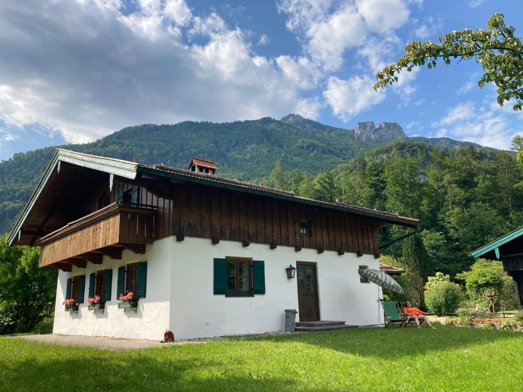 a small white house with mountains in the background at Ferienhaus Lois & Lisl in Schleching