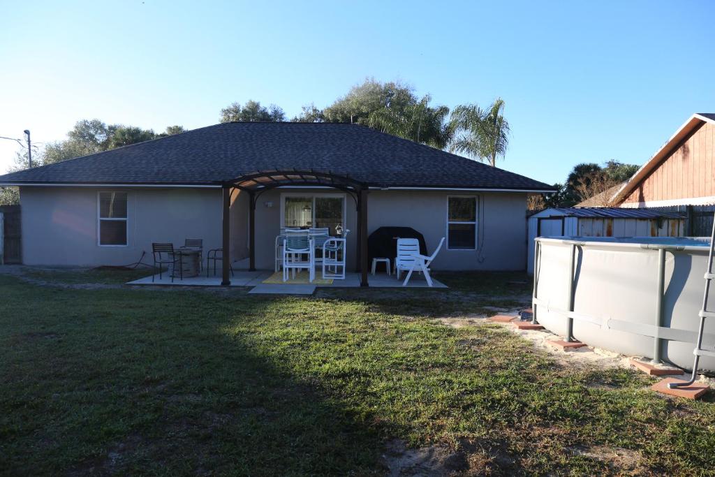 a house with a porch with a table and chairs at 3-bedroom home between the beach & theme parks in Deltona