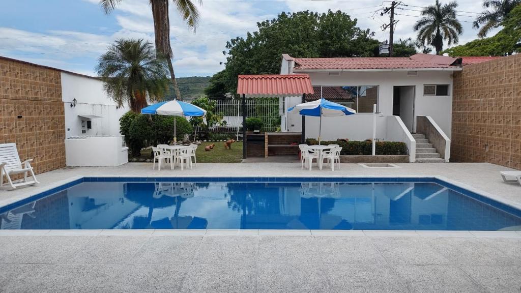 einen Pool mit Stühlen und Sonnenschirmen vor einem Haus in der Unterkunft Casaquinta Melgar in Melgar