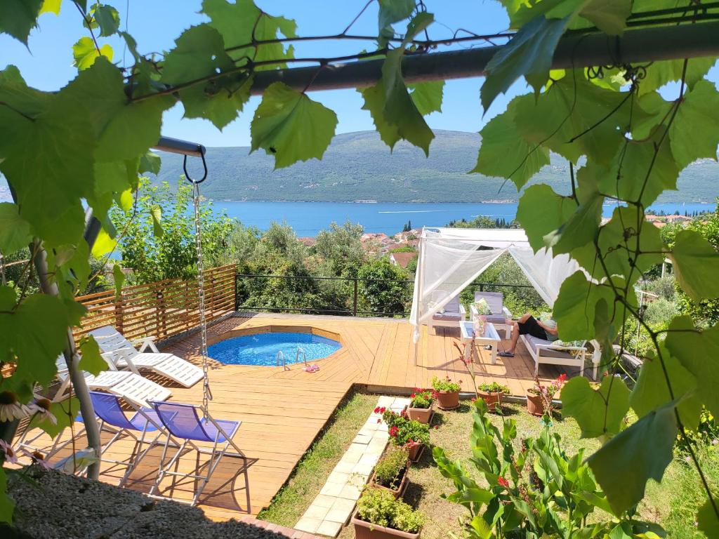 a backyard with a wooden deck and a swimming pool at Sunrise Apartments Baošići in Herceg-Novi