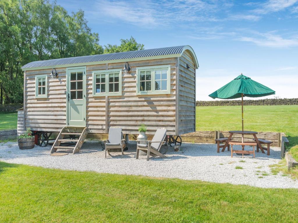 a tiny house with a picnic table and an umbrella at The Wensleydale - Uk40152 in Rathmell