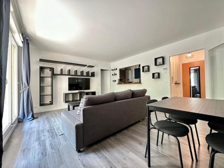 un salon avec un canapé et une table dans l'établissement Le cosy de Disney Land paris, à Bussy-Saint-Georges