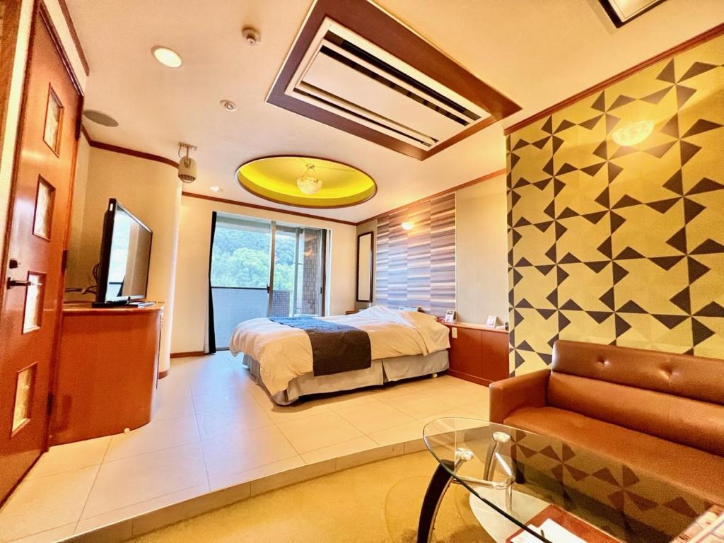 1 dormitorio con 1 cama y 1 sofá en una habitación en K2 SKY Resort Itoshima Love Hotel, en Itoshima
