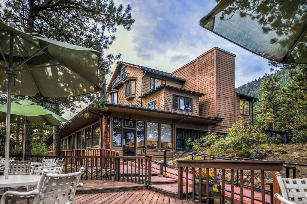 a large house with a deck with tables and chairs at The Historic Crag's Lodge in Estes Park