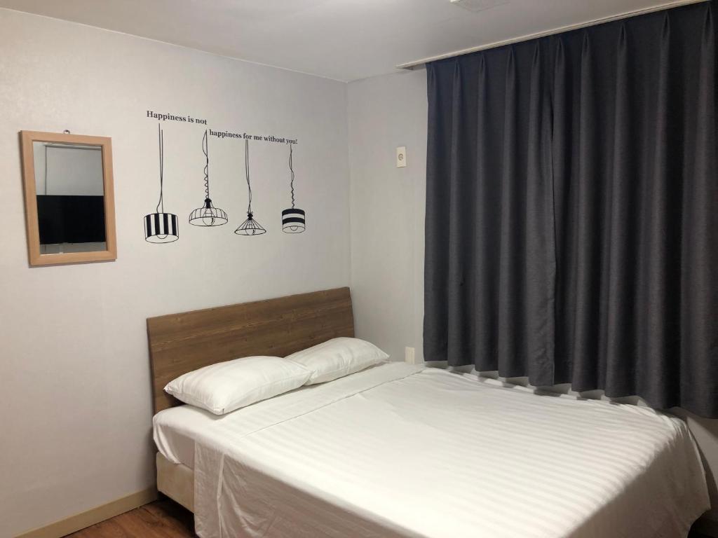 a bedroom with two beds and a window with lights at Dam Stay Jeju in Jeju