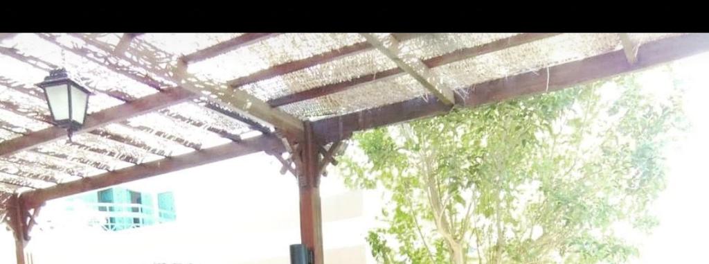 a wooden pergola with a street light in front of a window at ادهم هيبه in Alexandria