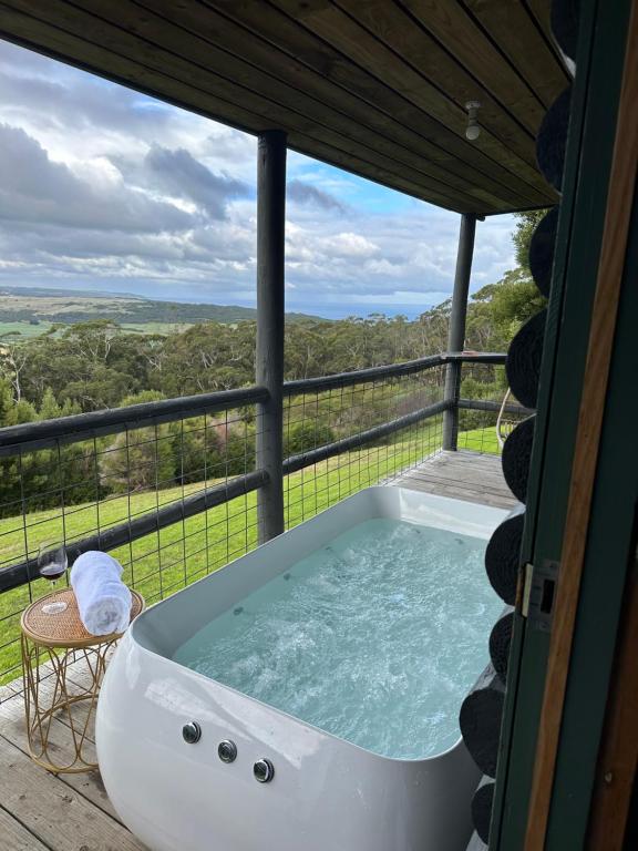 a bath tub on a deck with a view at Glenaire Cottages in Glenaire