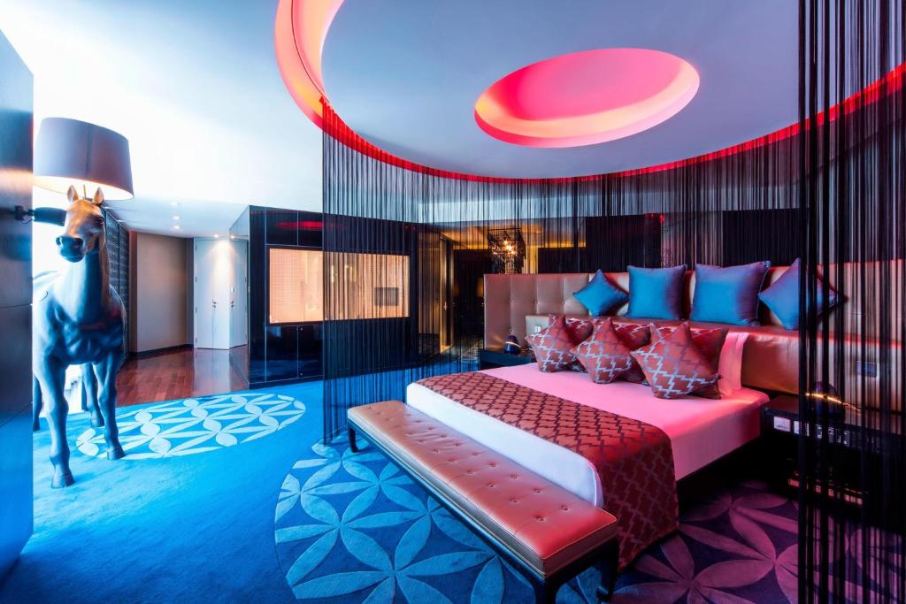 een slaapkamer met een bed met rood en blauw bij W Doha in Doha