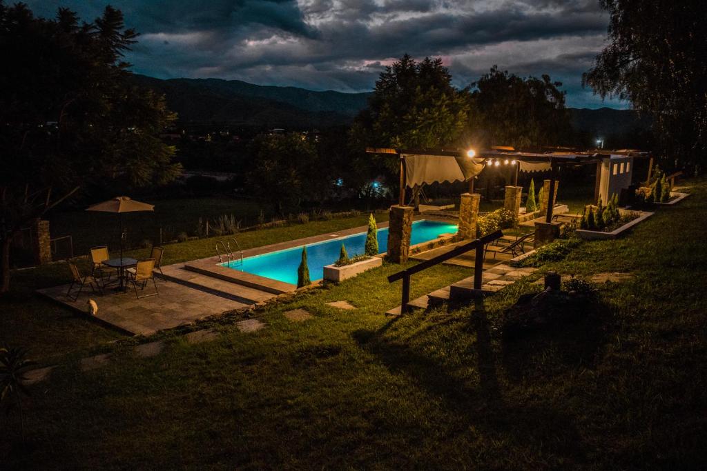 una piscina en un patio por la noche en Casa de Campo La Montaña, en Tarija