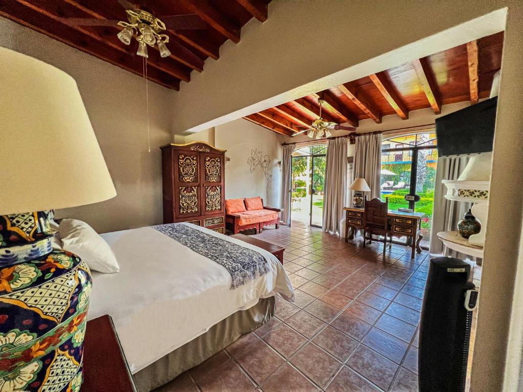 a bedroom with a bed and a living room at Hacienda de las Flores in San Miguel de Allende