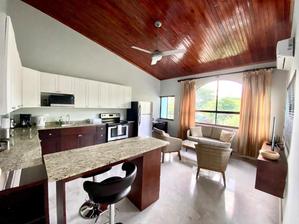 uma cozinha com um balcão e uma sala de estar em Stylish Fully Loaded Turquoise Getaway em Coco