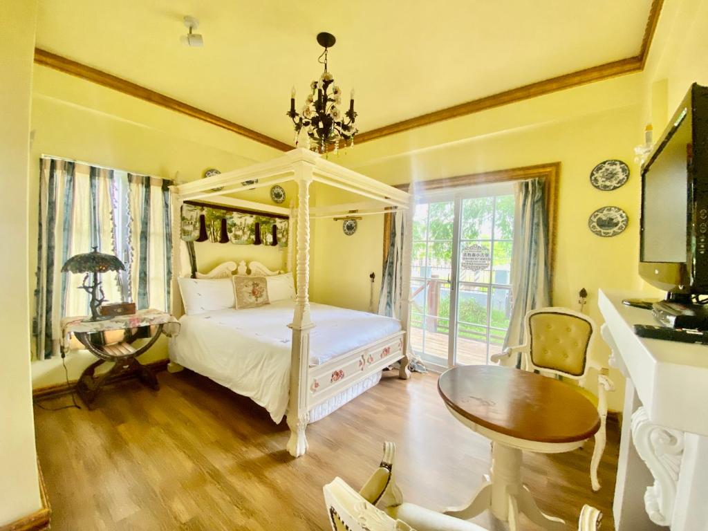 a bedroom with a white canopy bed and a table at England Castle B&amp;B in Wujie