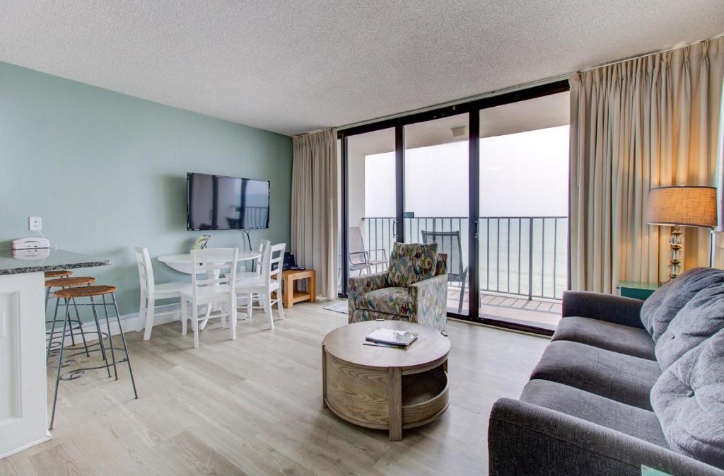 a living room with a couch and a table at 1104 Starfish Room by Atlantic Towers in Carolina Beach