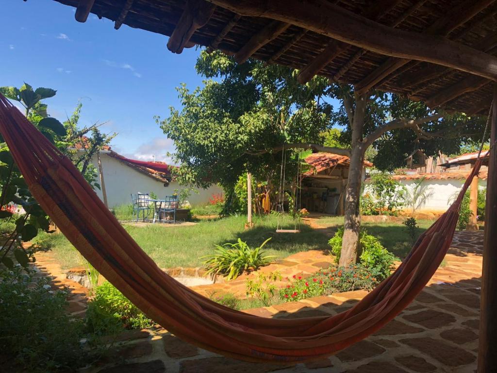 a hammock in front of a yard with a house at El Principito Hospedaje in Barichara