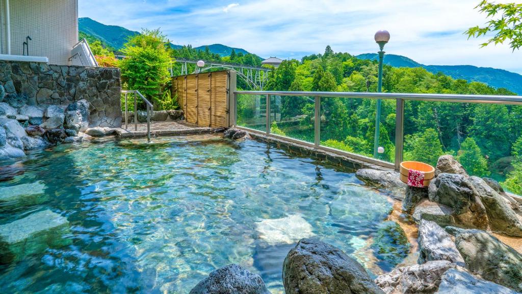 een zwembad met rotsen in het water bij Ooedo Onsen Monogatari Premium Gero Shinkan in Gero