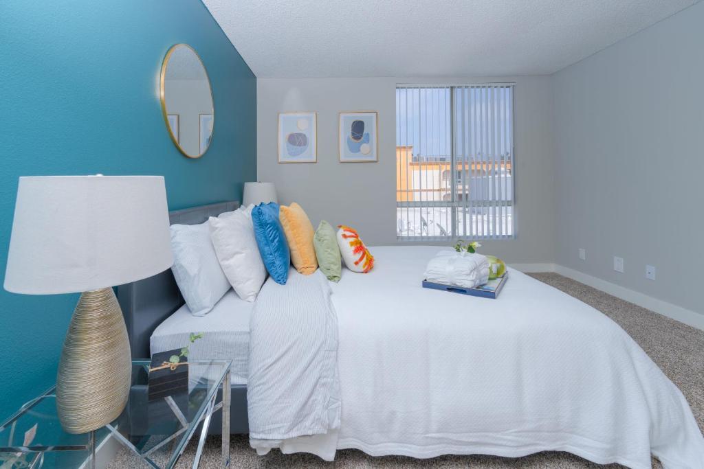 a bedroom with a white bed and a blue wall at Universal Studios 8 min drive Two bedroom Apartment with free parking in Los Angeles
