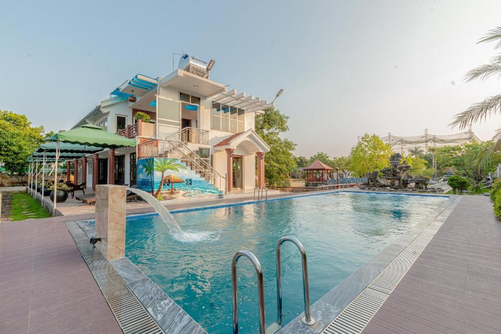 a swimming pool with a water slide in front of a house at Hoa Lu Garden in Ninh Binh
